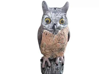 דחליל מפלסטיק בצורת ינשוף זעוף פנים ניצב על בול עץ להרחקת יונים