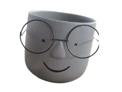 עציץ קרמי אפור עם ציור פנים ומשקפיים,