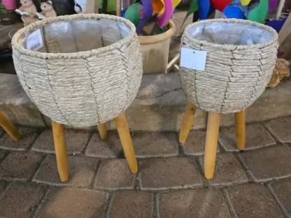 עציץ קש עמוק בצבע טבעי בקוטר 19 או 24 ס"מ עם ציפוי ניילון פנימי לחיפוי עציץ פורח על 3 רגלי עץ טבעי