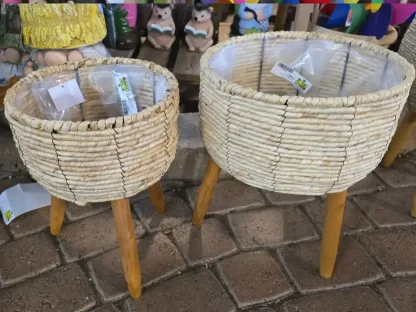 עציץ קש בצבע טבעי או לבן בקוטר 19 או 24 ס"מ עם ציפוי ניילון פנימי לחיפוי עציץ פורח על 3 רגלי עץ טבעי