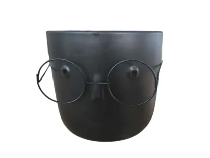 עציץ קרמי שחור עם ציור פנים ומשקפיים,