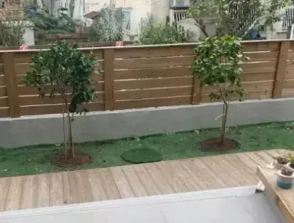 עצי הדר בתוך מכלים טמונים בגינת מרפסת