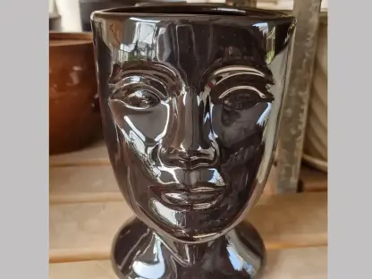 עציץ קרמיקה בצורת פנים מבריקות בצבע חום כהה לשתילה